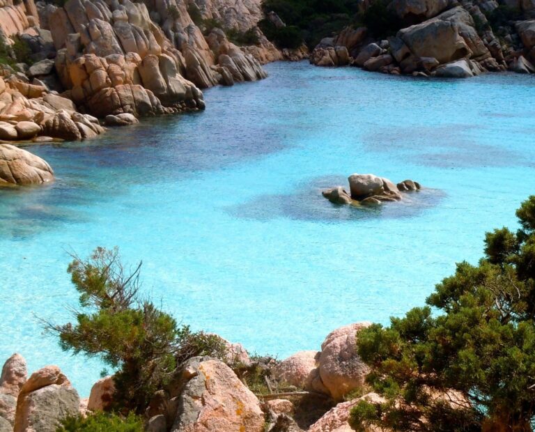a beautiful cove with crystal clear sea water, surrounded by rocks in Sardinia
